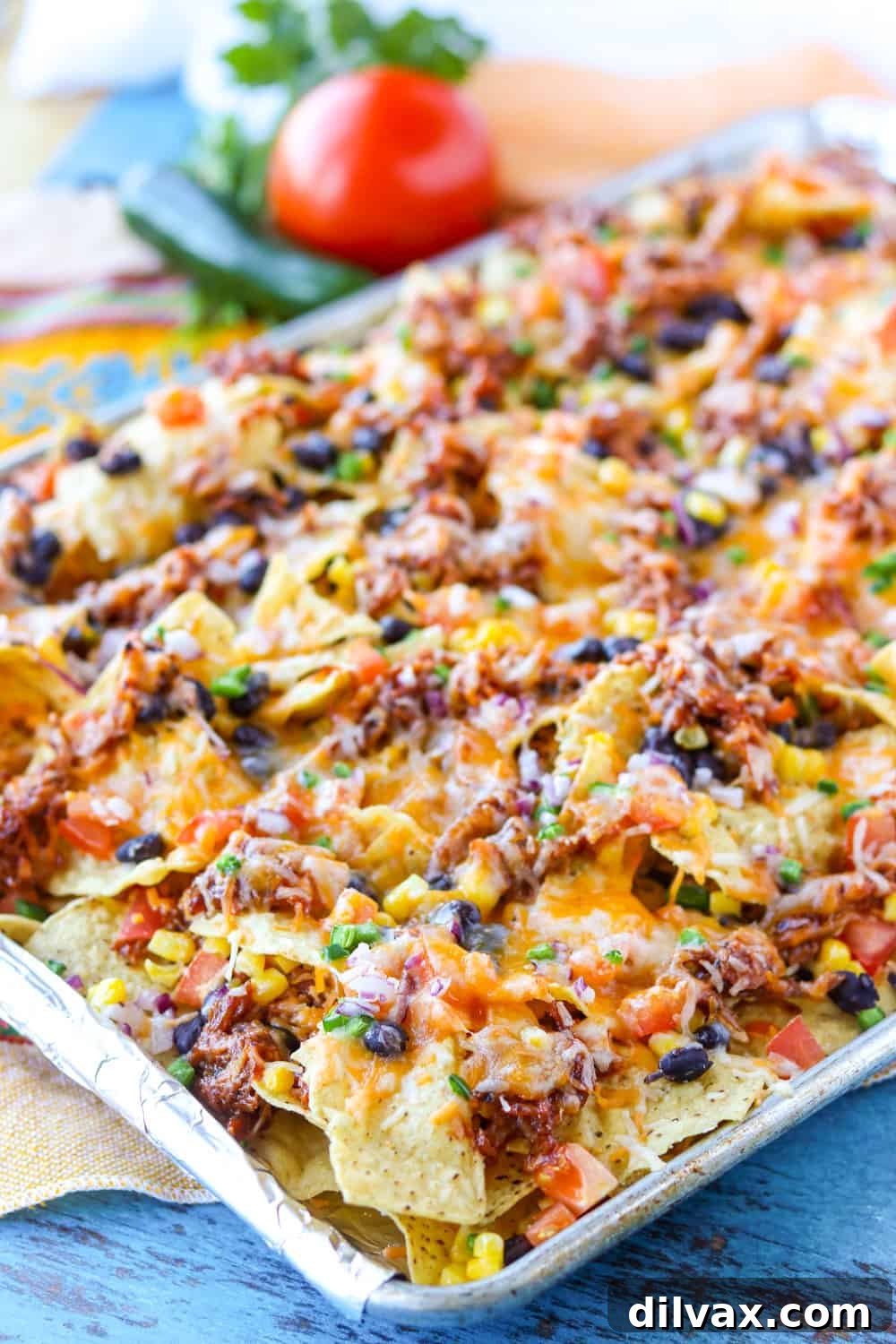 Loaded BBQ Chicken Nachos, hot and fresh from the oven, served on a baking sheet.