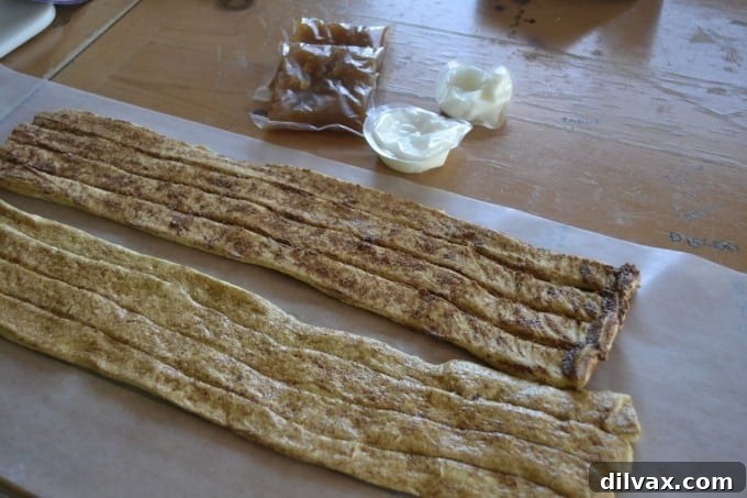 Process of unrolling Pepperidge Farm Sweet Roll dough onto wax paper for preparation