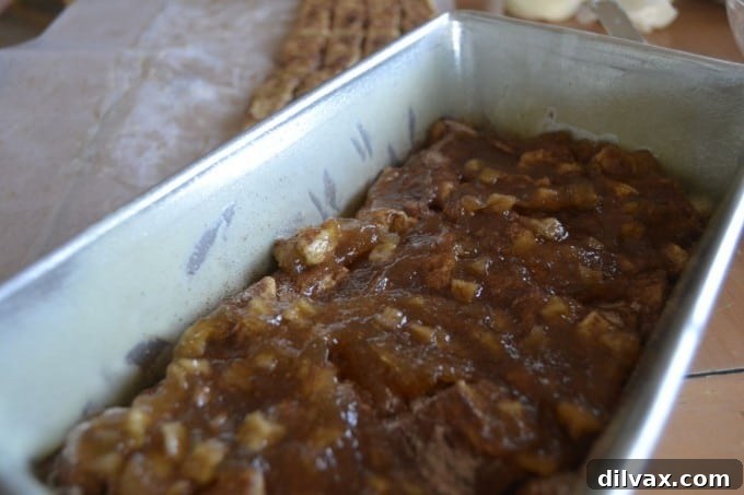 Sprinkling cinnamon sugar and spreading apple filling over the first layer of sweet roll dough
