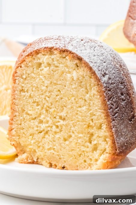 A slice of Lemon Olive Oil Cake, showcasing its vibrant yellow crumb and elegant texture.