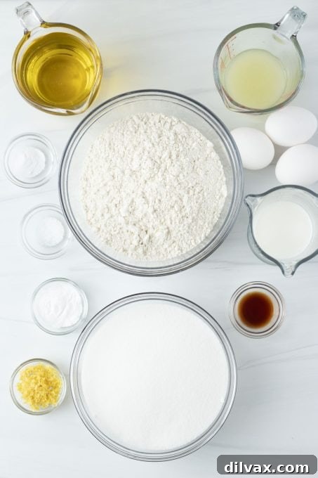 Ingredients for Lemon Olive Oil Cake laid out, including lemons, flour, sugar, and olive oil.