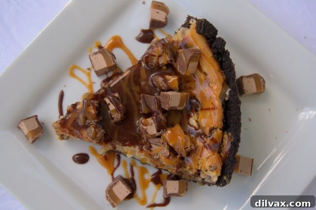 Mom It Forward Family Favorites 14 A slice of luscious Milky Way Cheesecake Pie, showcasing its creamy filling and chocolatey, caramel layers, served on a plate.