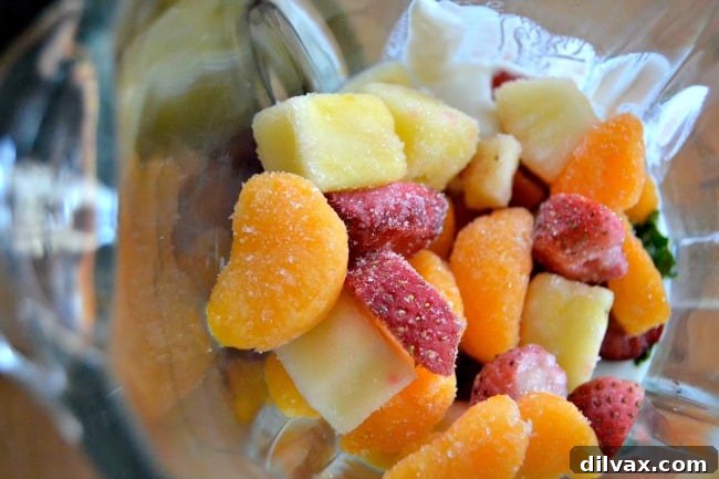 Mom It Forward Family Favorites 4 A vibrant green Winter Smoothie in a glass, garnished with fresh fruit and chia seeds, highlights its healthy and refreshing qualities.