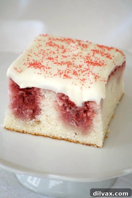 This Strawberry Poke Cake made from scratch with a white cake, strawberry sauce and cream cheese frosting is a perfect Valentine's Day or any day dessert.