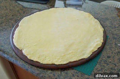 Galette dough rolled out on a baking surface with the strawberry rhubarb filling piled in the center, leaving a border for folding.