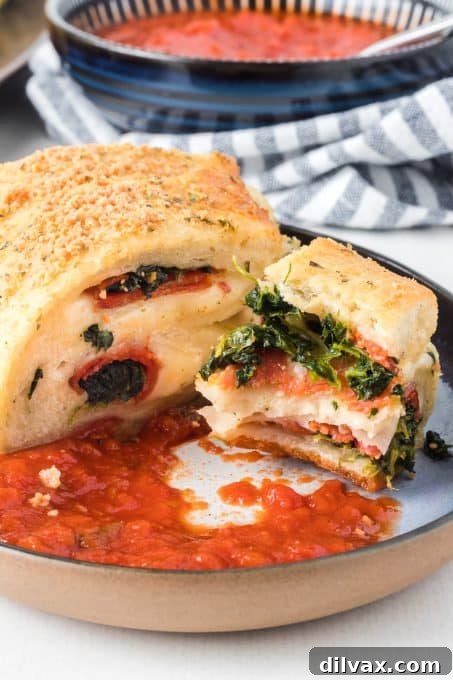 A slice of Stuffed Spinach Bread with a bite taken out, showing the melted cheese and filling.