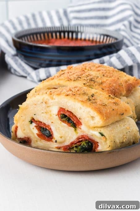 Close-up of Pepperoni Bread stuffed with vibrant spinach and melted cheese.
