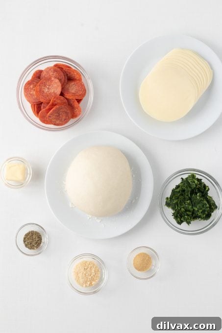 Ingredients for Spinach Pepperoni Bread laid out on a cutting board.
