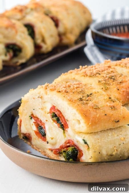 Close-up of a Spinach Pepperoni Bread slice with visible layers of cheese and pepperoni.