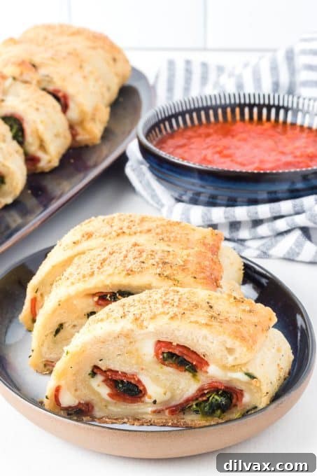 Close-up of pizza dough being stuffed with spinach, pepperoni, and provolone cheese before rolling.