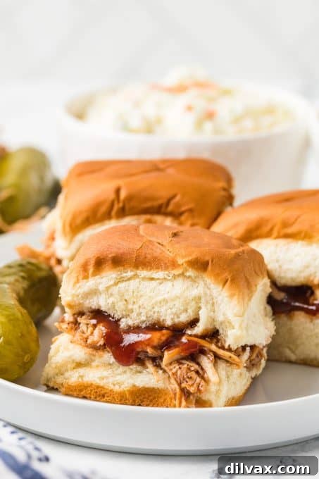 A plate of chicken and BBQ sauce sliders, ready to be enjoyed, showing the delicious filling.