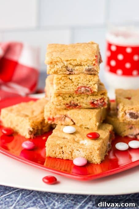A stack of M&M Blondies with festive M&M's, ready to be served.