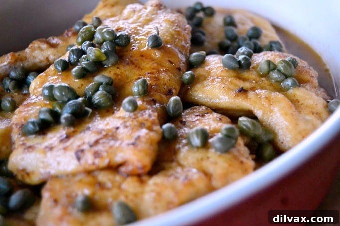 Close-up of a skillet with the savory lemon-caper sauce for Chicken Piccata.