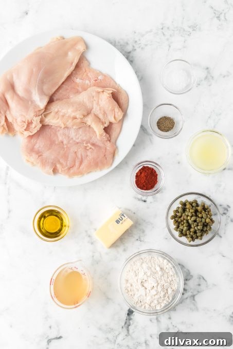 Ingredients for Easy Chicken Piccata including chicken breasts, lemons, capers, butter, olive oil, and spices.