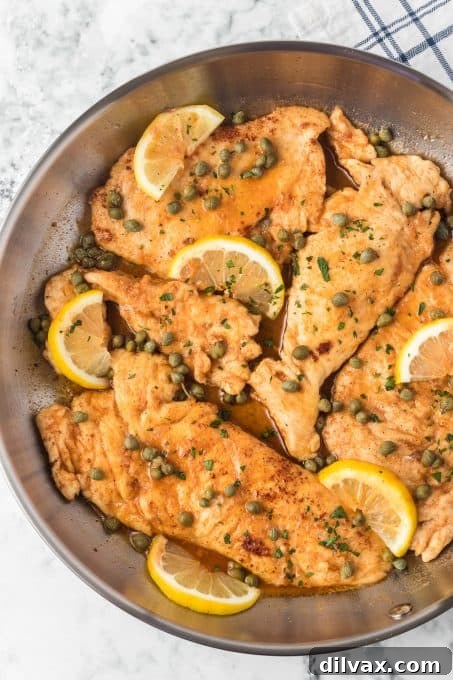Finished Chicken Piccata garnished with fresh lemon slices and capers.