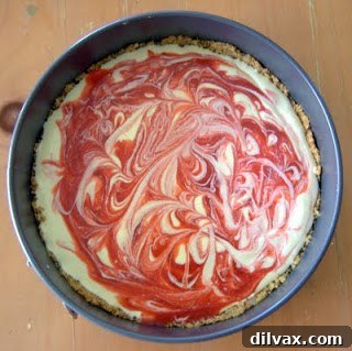 Strawberry puree being swirled into cheesecake batter.