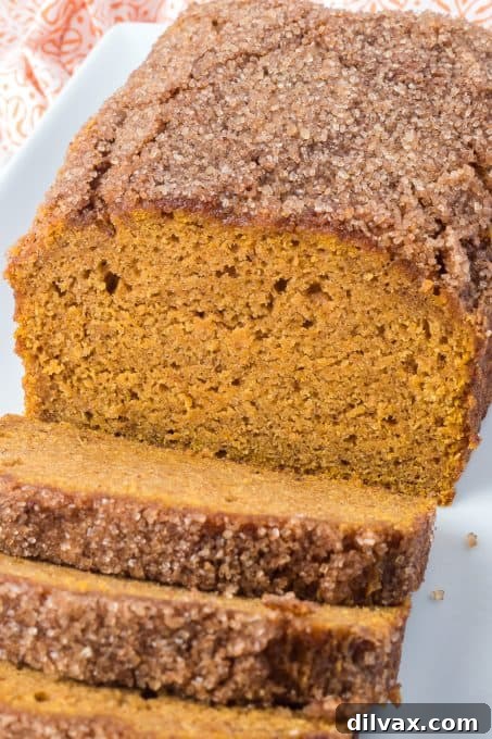 Deliciously Spiced Pumpkin Bread 3 Two slices of pumpkin bread on a cutting board, ready to serve.