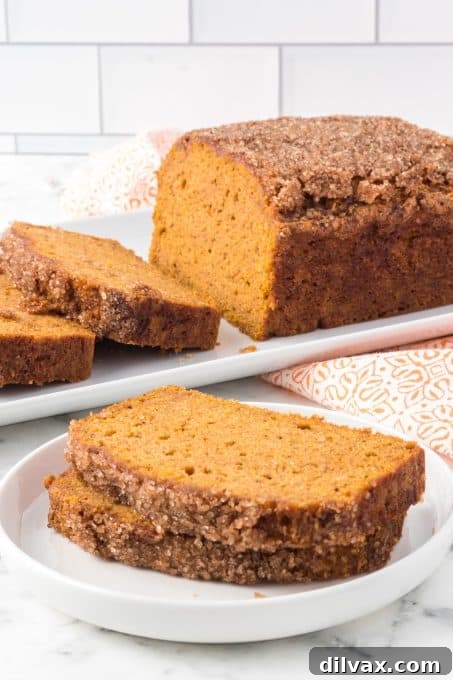Deliciously Spiced Pumpkin Bread 8 A full loaf of homemade pumpkin bread cooling on a wire rack.