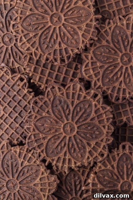 An artfully arranged close-up of a chocolate pizzelle, emphasizing its beautiful pattern and rich color.