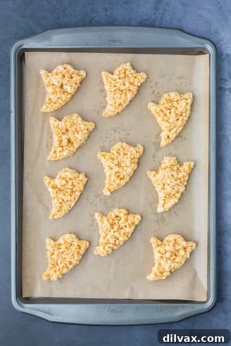 Rice Krispie Treats cut into ghost shapes, ready for chocolate coating