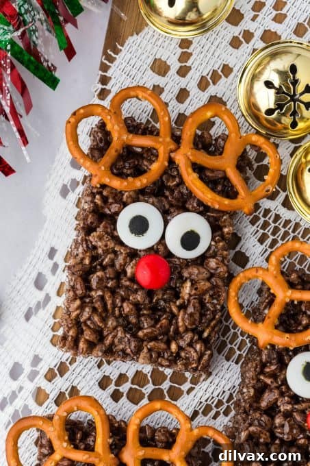 Close-up of a finished chocolate Reindeer Treat, showing candy eyes, red M&M nose, and pretzel antlers.