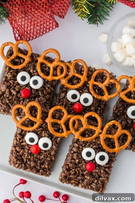 A pile of Reindeer Rice Krispie Treats ready for serving on a wooden board.