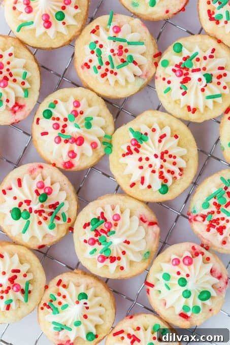Yuletide Cookie Delights 7 Finished Christmas Sugar Cookie Cups with creamy white frosting and vibrant red and green sprinkles.