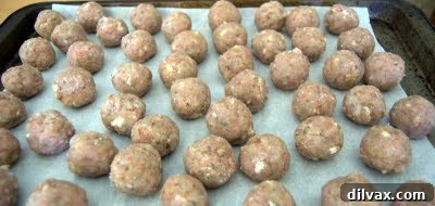 Chilled cake balls arranged neatly on a parchment-lined baking sheet.