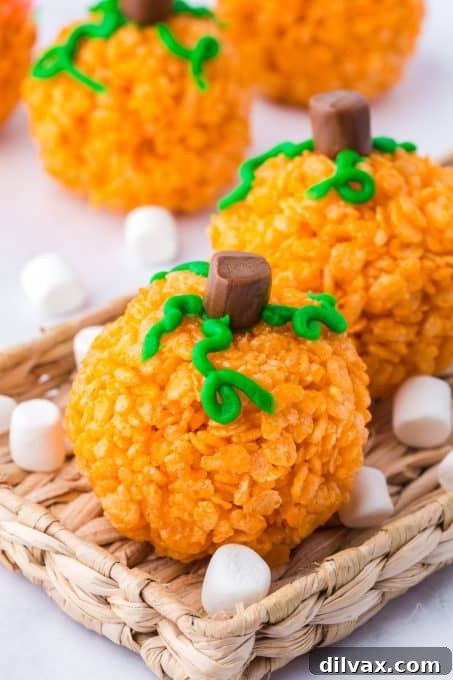 Stacked Halloween Pumpkin Rice Krispie Treats on a festive plate