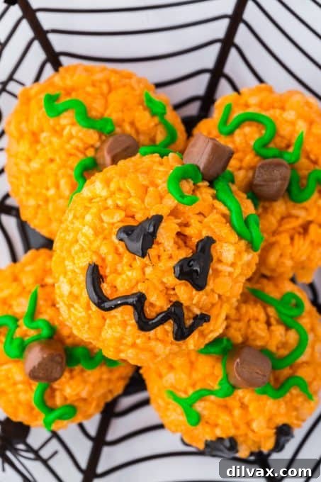 A creatively decorated rice cereal pumpkin treat with a jack-o'-lantern face
