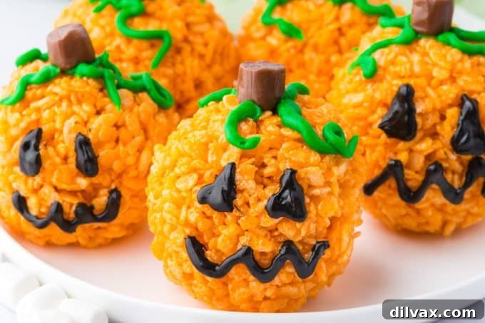 A tray of pumpkin Rice Krispie treats, some decorated, some plain