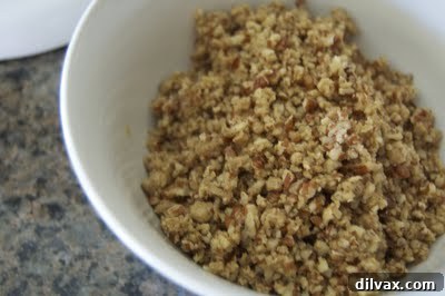 Close-up of the egg yolk, brown sugar, salt, and chopped pecans mixture, looking creamy and ready for the next step.
