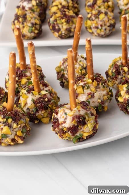 Several Cranberry Cheese Balls neatly arranged on a white serving platter