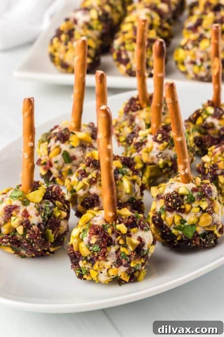 Pretzel sticks neatly inserted into easy-to-grab cheese appetizers.