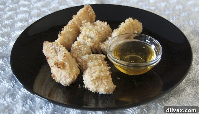 Close-up of crispy honey ginger chicken served on a plate, garnished with fresh herbs and a honey drizzle