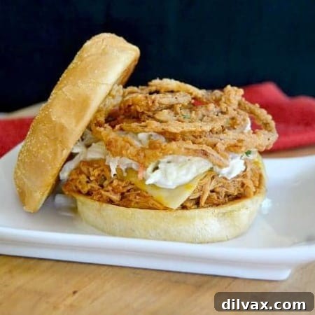 Shredded, slow cooked, barbecue chicken on a Cobblestone Bread Co. Corn Dusted Kaiser Roll topped with melted cheese, cole slaw and onion strings!