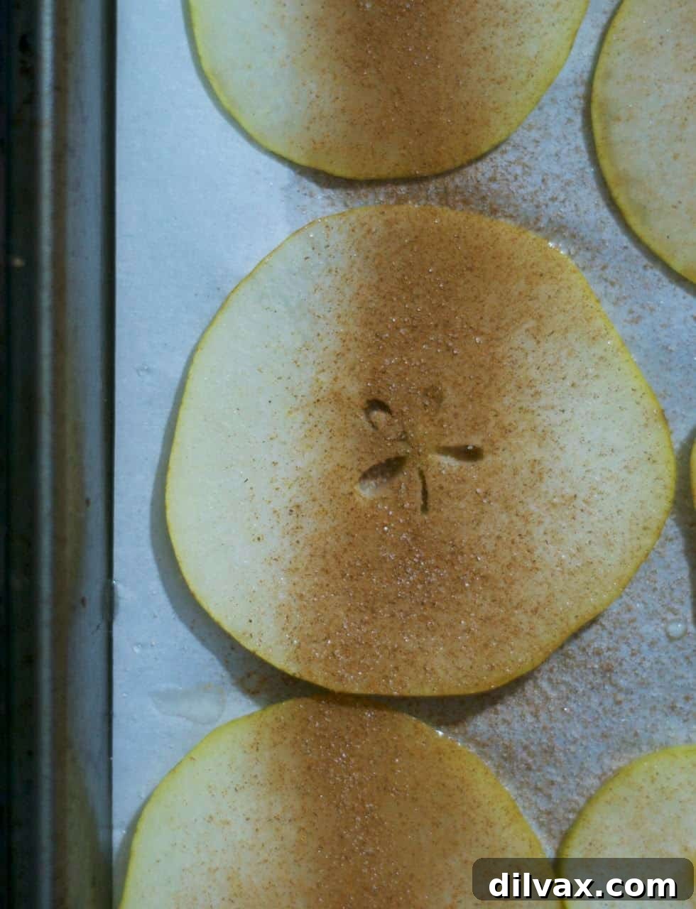 Perfectly sliced pears arranged on a baking sheet, ready for the oven.