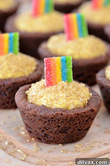 Cookie cups filled with gold candy and a rainbow arch.