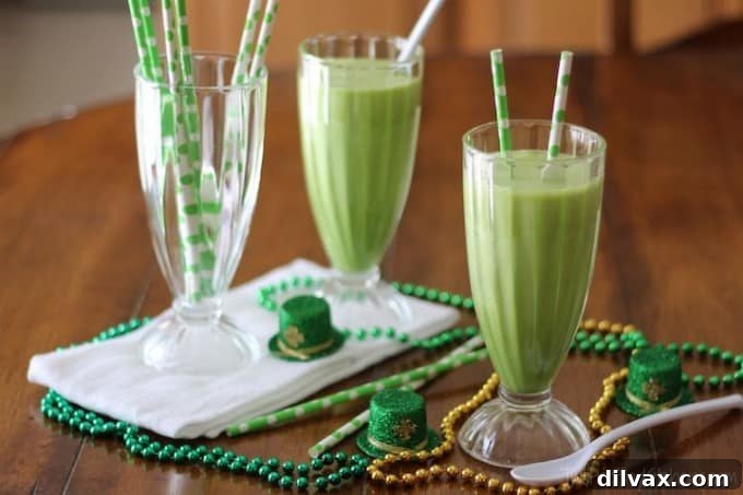 A vibrant green smoothie topped with whipped cream and a cherry, a healthier version of a Shamrock Shake.