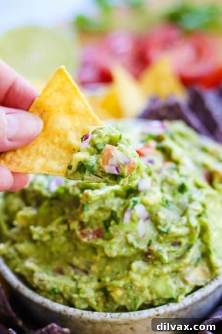 Touchdown Treats: 33 Effortless Game Day Recipes 6 Crispy tortilla chips being dipped into homemade guacamole.