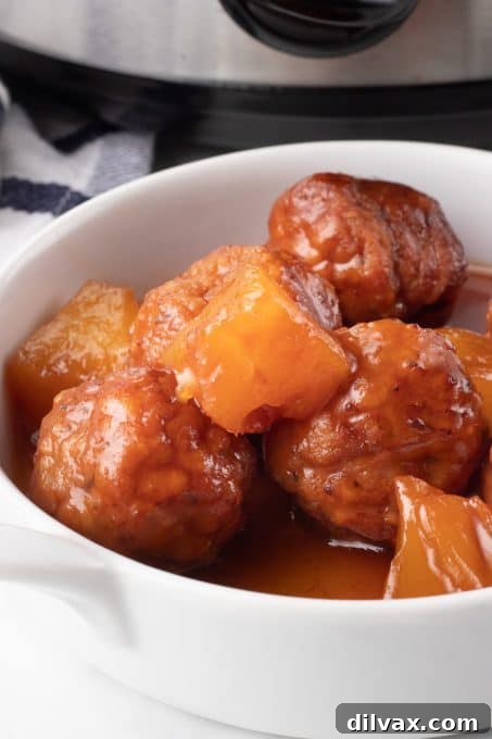 Touchdown Treats: 33 Effortless Game Day Recipes 18 Slow Cooker Sweet and Sour Meatballs in a decorative serving bowl.