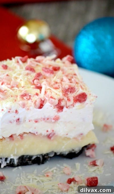 Peppermint Dream Dessert - an Oreo crust, cheesecake pudding, a creamy peppermint layer, crunchy peppermint baking chips and white chocolate make this a fabulous holiday treat!