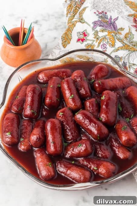 A bowl of hot cocktail sausages with toothpicks and a napkin for serving.
