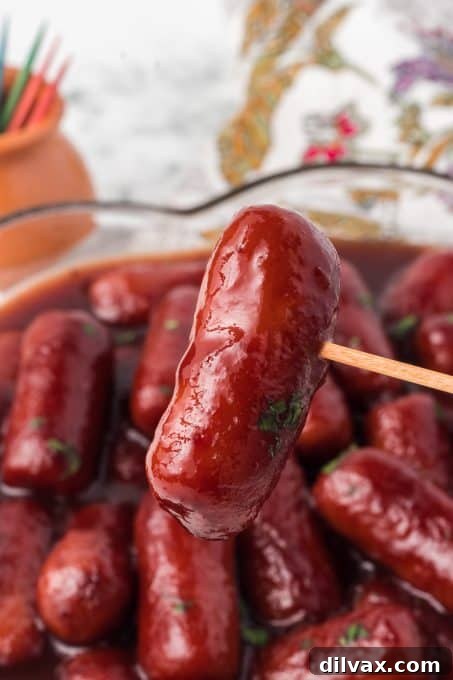 A single cocktail sausage perfectly glazed on a toothpick, ready to be enjoyed.