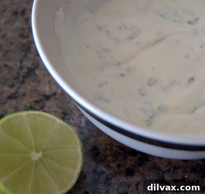 Lime sour cream in a bowl, ready to be served with potato skins.