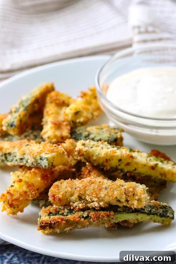 A plate of crispy Parmesan Zucchini Sticks served with a bowl of Ranch dressing