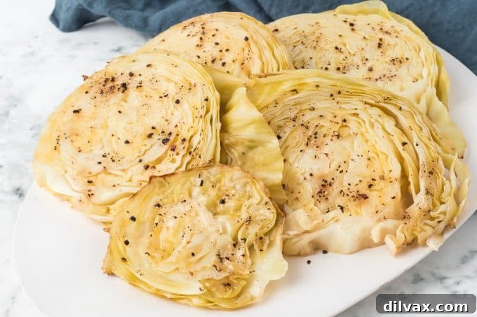 Crispy Roasted Cabbage Steaks 2 Slices of roasted green cabbage on a baking sheet, golden brown and slightly crispy at the edges.