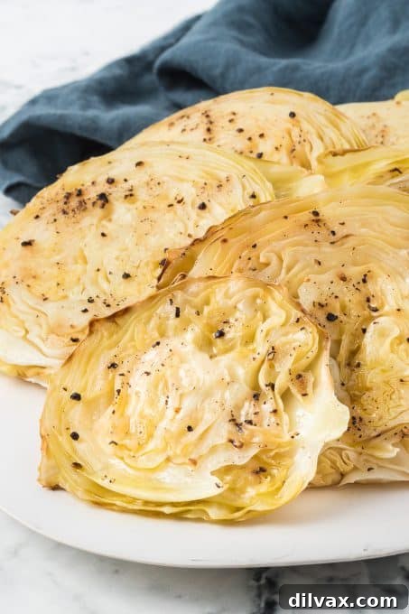 Crispy Roasted Cabbage Steaks 7 Close-up of roasted green cabbage steaks on a rustic plate, showing tender texture and crispy edges.