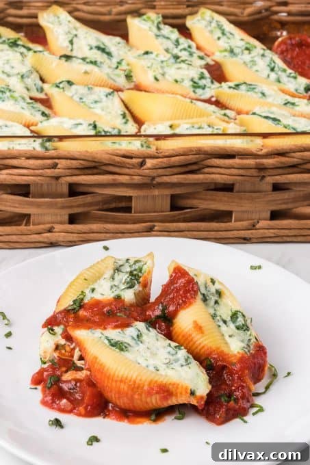 Marina covering pasta shells with ricotta spinach filling on a plate.