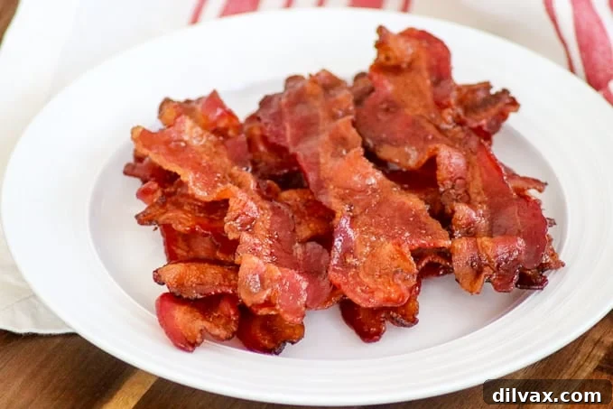 Crispy, perfectly cooked bacon slices arranged on a plate.